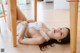 A woman laying on the floor under a wooden table.