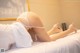 A woman laying on a bed in a white lingerie.