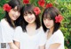 A group of three young women standing next to each other.