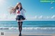 A girl in a school uniform standing on the beach.