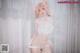 A woman in a white lingerie posing for a picture.
