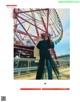 A woman standing in front of a ferris wheel.