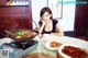 A woman sitting at a table with a plate of food.