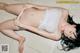A woman in a white bikini laying on the floor.